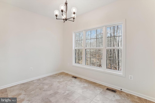 unfurnished room with a chandelier