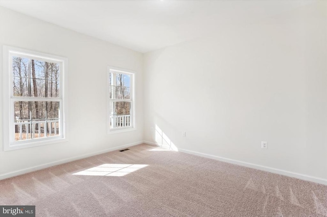 spare room featuring light colored carpet