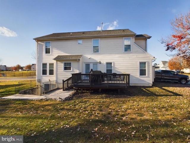 rear view of property with a yard and a deck