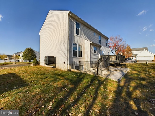 back of house with a deck, a patio area, and a lawn