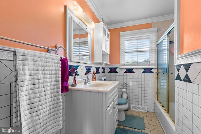 full bathroom featuring enclosed tub / shower combo, tile patterned floors, toilet, tile walls, and ornamental molding