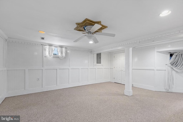 basement with light colored carpet, ornamental molding, and electric panel