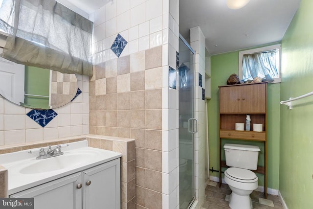 bathroom featuring tile walls, vanity, an enclosed shower, and toilet