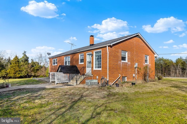 rear view of house with a lawn and cooling unit