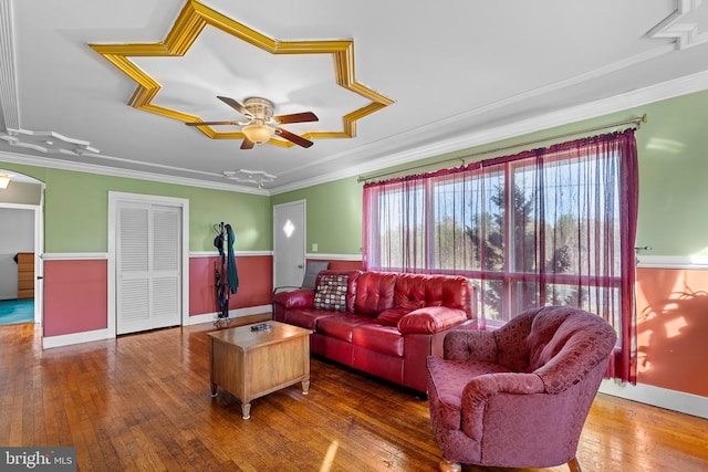 living room featuring ceiling fan, wood-type flooring, and ornamental molding