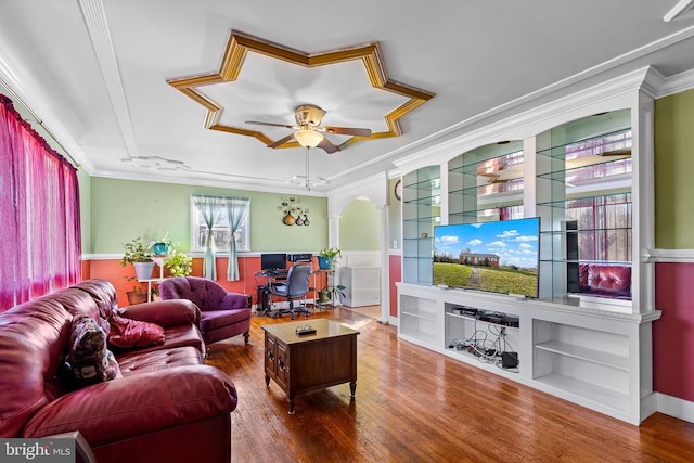 living room featuring hardwood / wood-style floors, ceiling fan, built in features, and ornamental molding