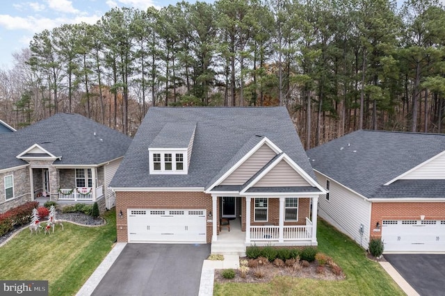 view of front facade featuring a garage, covered porch, and a front yard