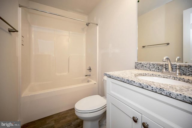 full bathroom featuring hardwood / wood-style flooring, vanity,  shower combination, and toilet