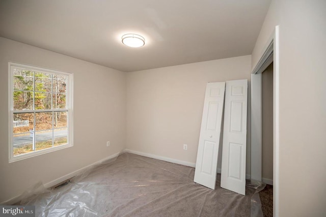 unfurnished bedroom featuring dark colored carpet and a closet