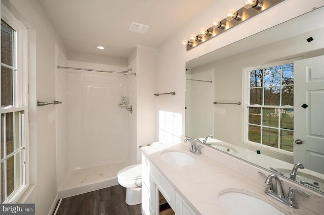 bathroom with a shower, toilet, vanity, and hardwood / wood-style flooring