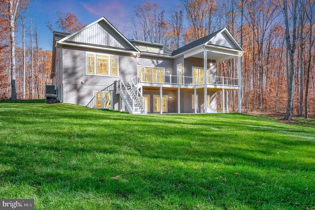 back house at dusk featuring a yard and a wooden deck