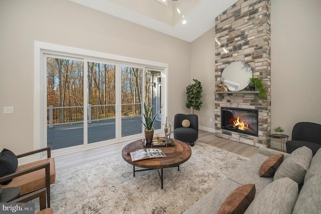 living room with a fireplace, high vaulted ceiling, and hardwood / wood-style flooring