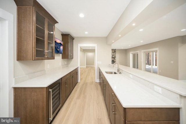 kitchen featuring sink, wine cooler, and light hardwood / wood-style flooring