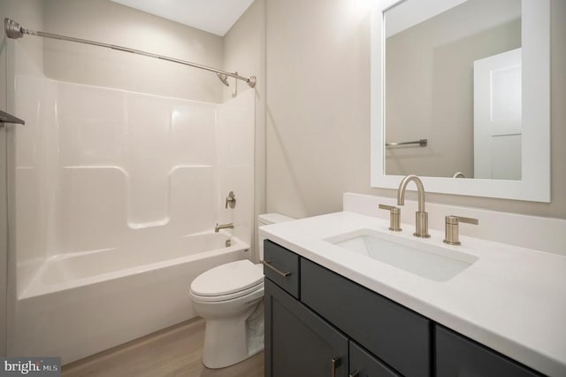 full bathroom featuring hardwood / wood-style floors, vanity,  shower combination, and toilet