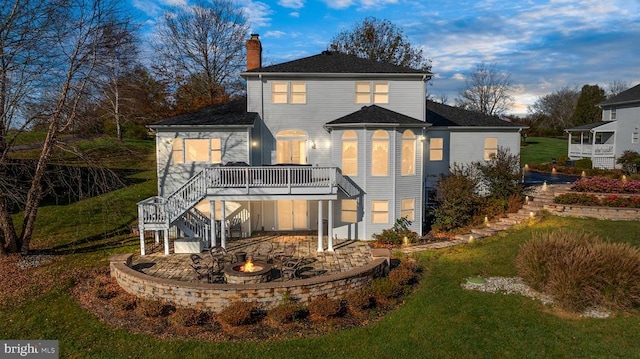 back of property featuring a yard, a patio, and a wooden deck