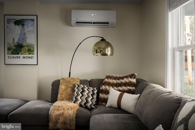 living room with a wall mounted air conditioner and plenty of natural light