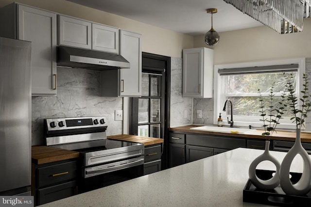 kitchen with gray cabinetry, sink, decorative backsplash, appliances with stainless steel finishes, and butcher block counters