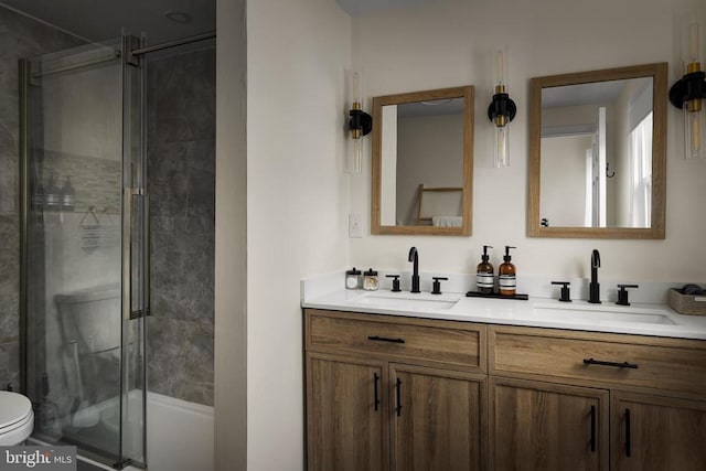 bathroom with vanity, a shower with shower door, and toilet