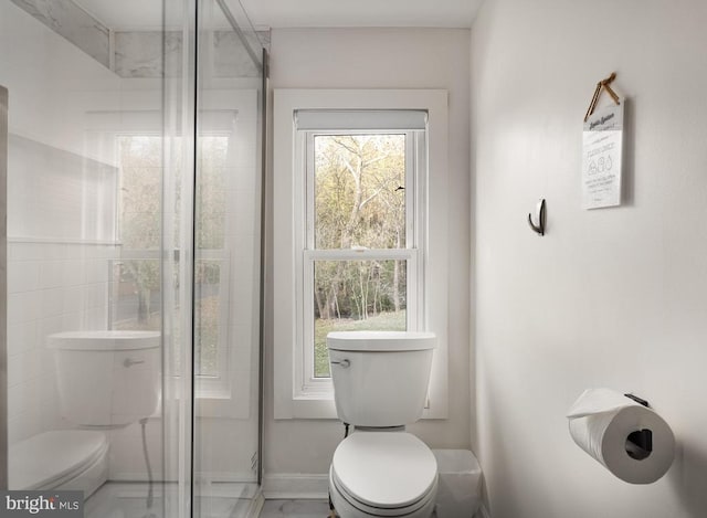 bathroom with an enclosed shower and toilet