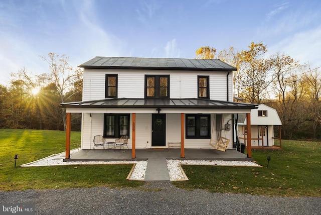 view of front of house with covered porch and a yard