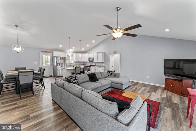 living room with wood-type flooring, high vaulted ceiling, and ceiling fan