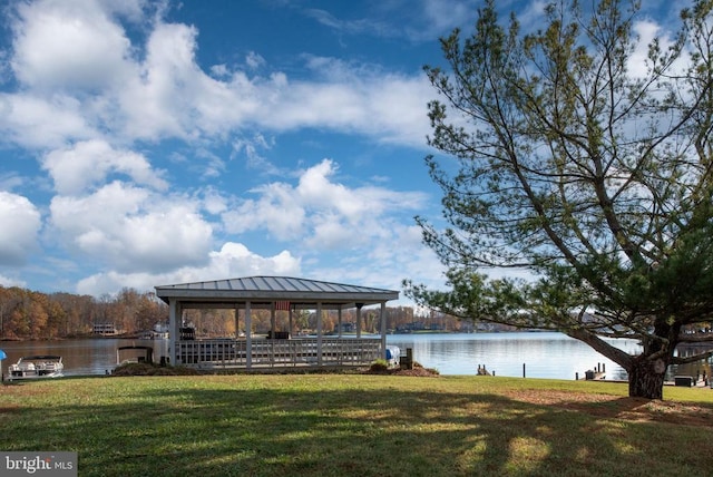 view of dock with a gazebo, a yard, and a water view