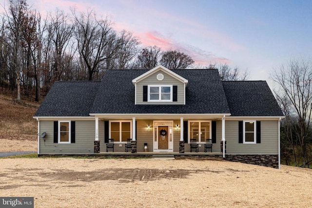 cape cod home featuring a porch