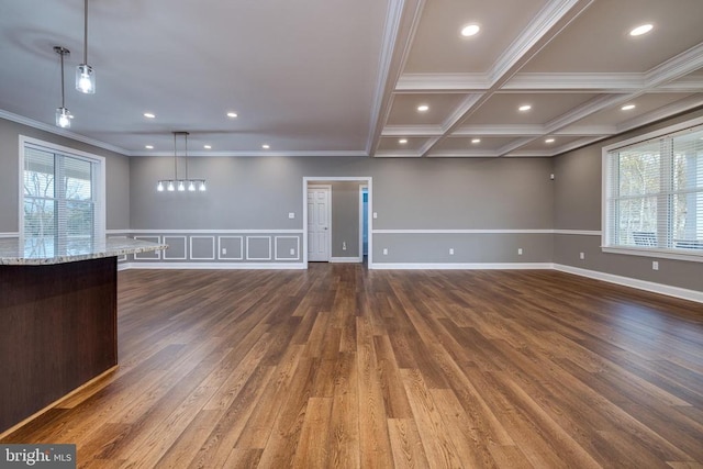 unfurnished living room featuring beam ceiling, crown molding, plenty of natural light, and dark hardwood / wood-style floors