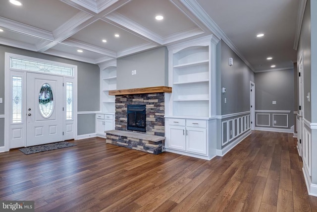 entryway featuring ornamental molding, coffered ceiling, dark wood-type flooring, beam ceiling, and a stone fireplace