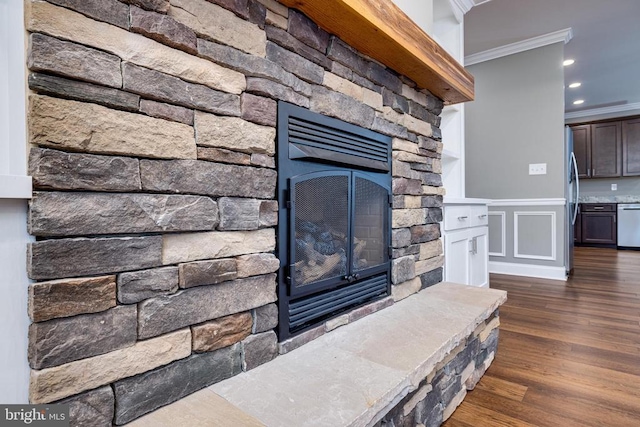 room details with a stone fireplace, crown molding, dishwasher, and hardwood / wood-style flooring