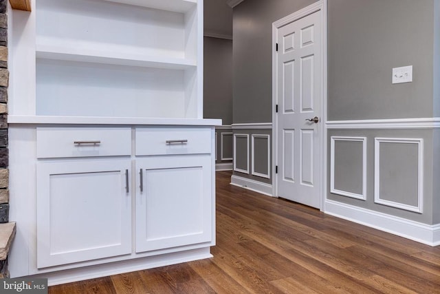 kitchen featuring dark hardwood / wood-style floors, white cabinetry, and ornamental molding