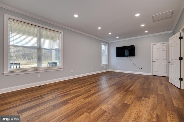 spare room with a healthy amount of sunlight, crown molding, and dark wood-type flooring