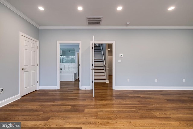 spare room with crown molding and dark wood-type flooring