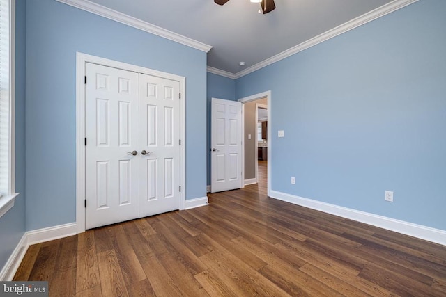 unfurnished bedroom with dark hardwood / wood-style flooring, a closet, ceiling fan, and ornamental molding