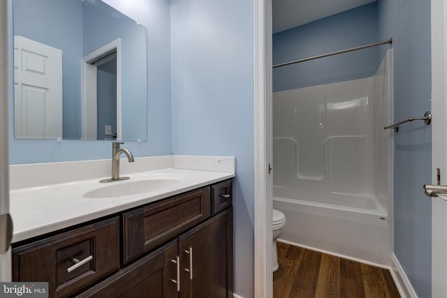 full bathroom with hardwood / wood-style floors, vanity, toilet, and shower / bathing tub combination