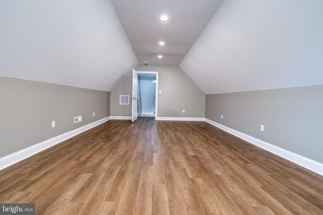 additional living space featuring wood-type flooring and vaulted ceiling