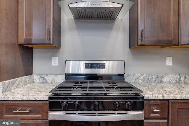 kitchen featuring stainless steel gas stove, extractor fan, and dark brown cabinetry