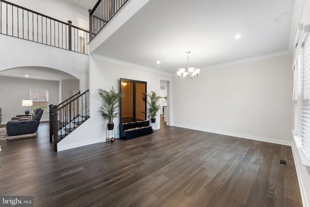 living room featuring dark hardwood / wood-style flooring, ornamental molding, and a notable chandelier