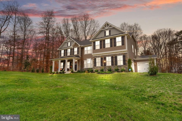 view of front of home featuring a porch, a garage, and a lawn