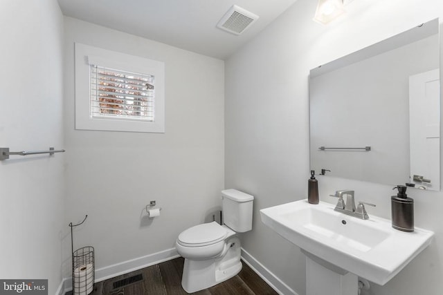 bathroom featuring toilet and wood-type flooring