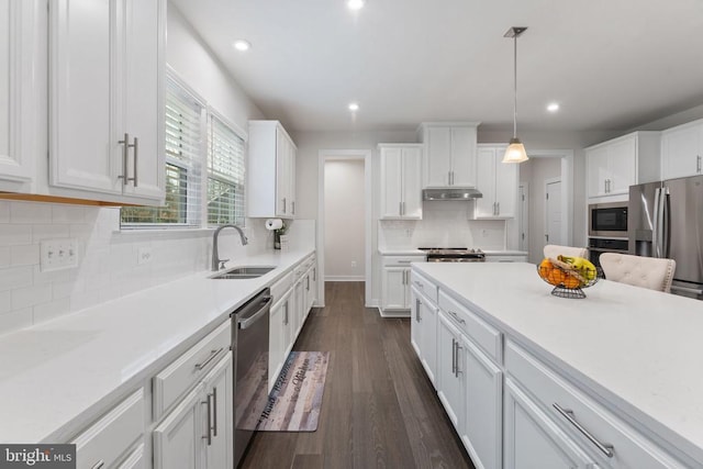 kitchen with sink, dark hardwood / wood-style flooring, decorative light fixtures, white cabinets, and appliances with stainless steel finishes