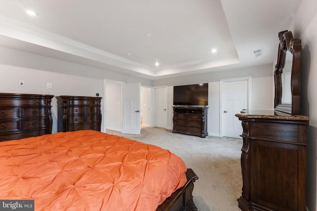 bedroom featuring light carpet and a raised ceiling