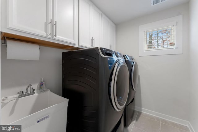 washroom featuring cabinets, independent washer and dryer, sink, and light tile patterned floors