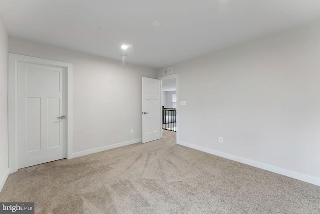 unfurnished room with light carpet