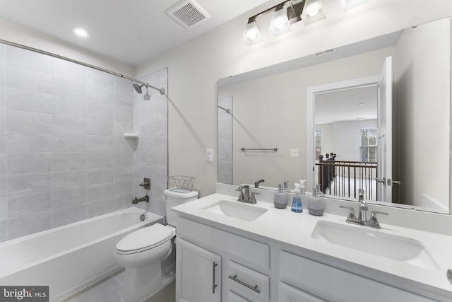 full bathroom featuring toilet, vanity, and tiled shower / bath