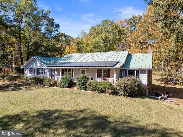 ranch-style home featuring a front lawn, a porch, and solar panels