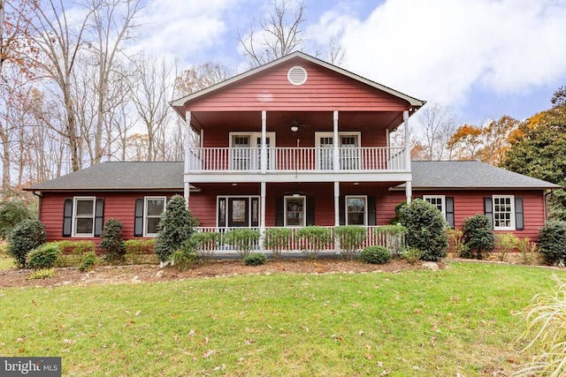 view of front property with a front yard and a balcony