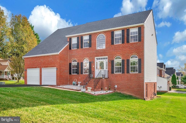 colonial-style house featuring a garage and a front lawn