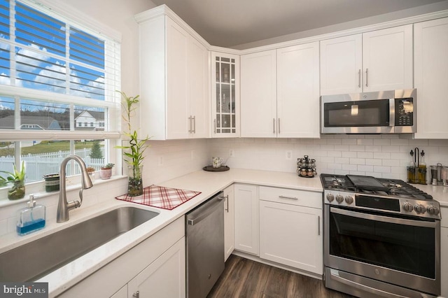 kitchen with white cabinets, plenty of natural light, sink, and appliances with stainless steel finishes