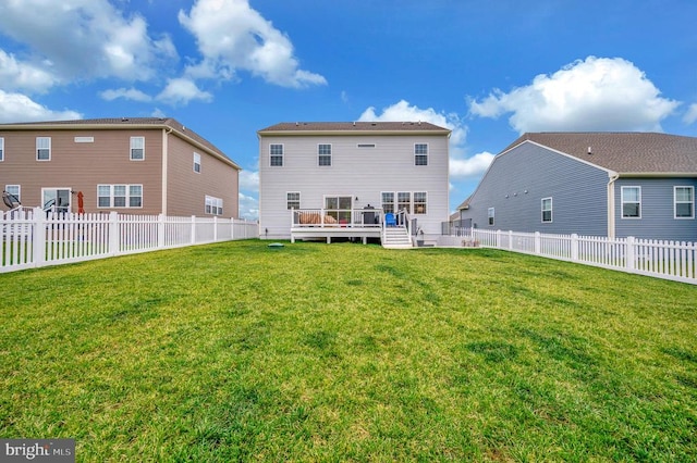 back of property with a lawn and a wooden deck